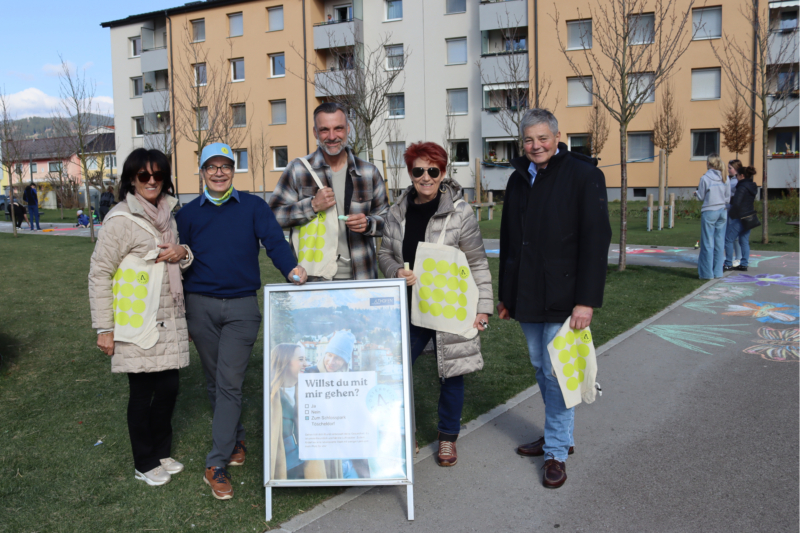 Stadträte und Stadträtinnen aus Althofen posieren mit einem Österreich zu Fuß Aufsteller und Goodies.