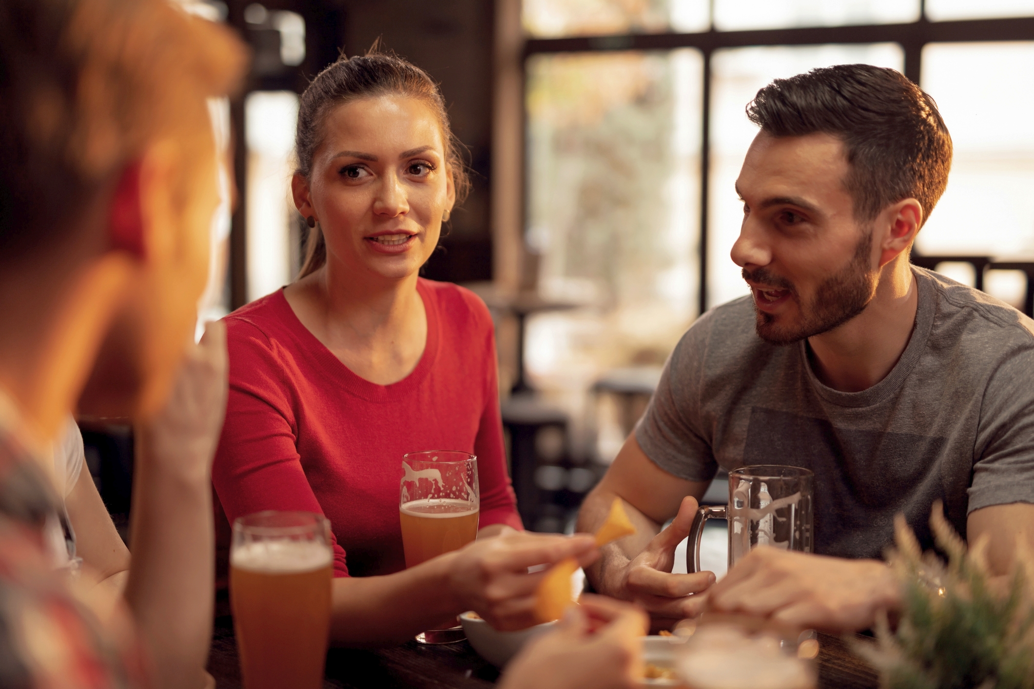 2 Personen sitzen am Tisch mit Bier und reden